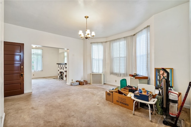 miscellaneous room featuring carpet floors and an inviting chandelier