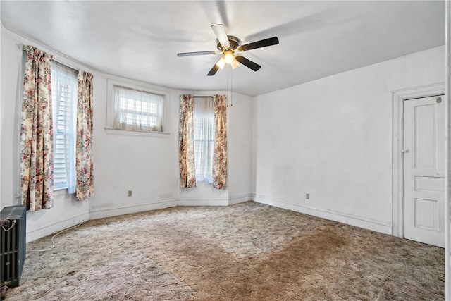 unfurnished room with ceiling fan and radiator heating unit