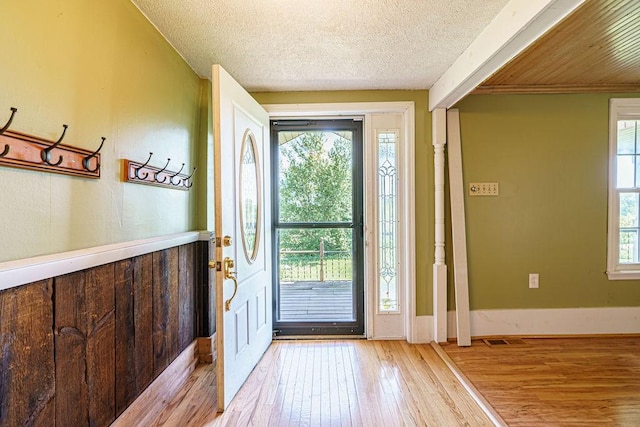 foyer with light hardwood / wood-style floors and a textured ceiling