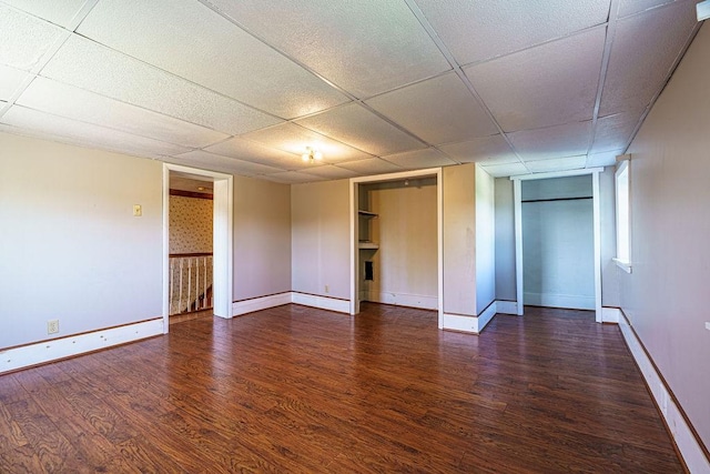 unfurnished bedroom with a paneled ceiling and dark hardwood / wood-style floors