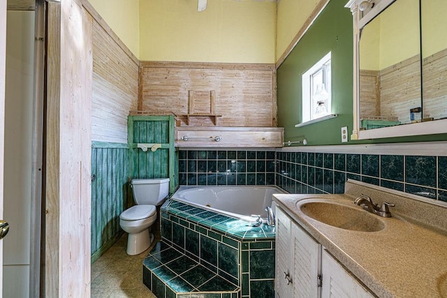 bathroom featuring vanity, toilet, and tiled tub