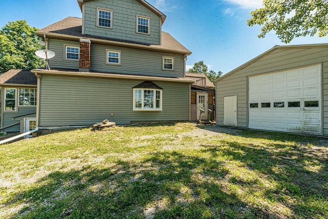 back of property with a yard, an outdoor structure, and a garage