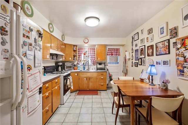 kitchen with sink, light tile patterned floors, and white appliances