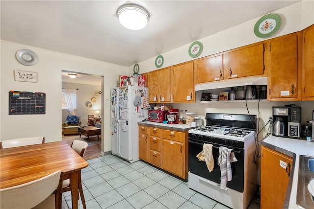 kitchen featuring light tile patterned floors and white appliances