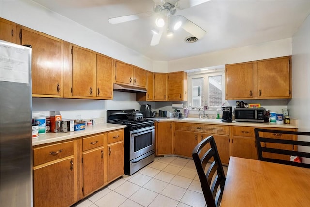 kitchen with ceiling fan, sink, light tile patterned flooring, and appliances with stainless steel finishes