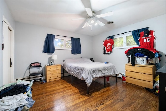 bedroom with ceiling fan, a baseboard radiator, and dark hardwood / wood-style floors