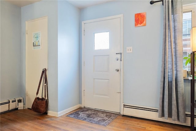 foyer featuring light wood-type flooring and a baseboard heating unit