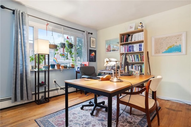 home office with hardwood / wood-style flooring and a baseboard heating unit