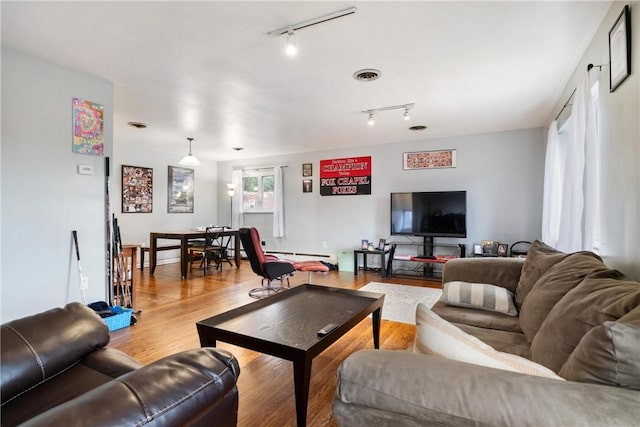 living room featuring rail lighting and light hardwood / wood-style floors