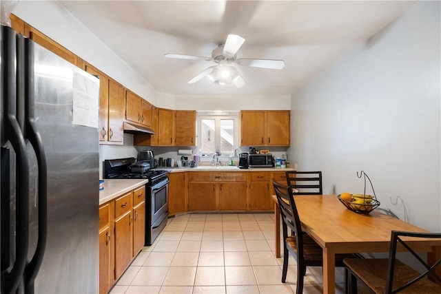 kitchen featuring ceiling fan, light tile patterned flooring, sink, and appliances with stainless steel finishes