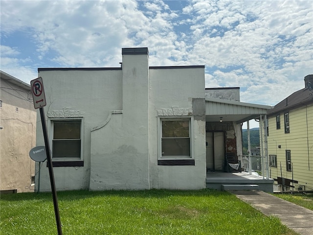 rear view of property featuring a lawn