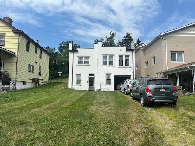 back of property with a yard and a garage