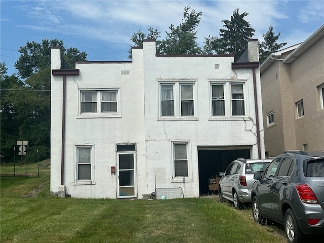 rear view of house with a garage and a yard