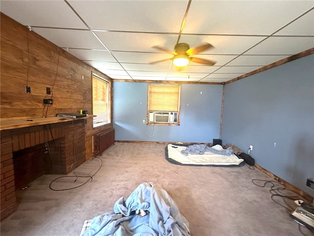 interior space with wooden walls, ceiling fan, and light colored carpet