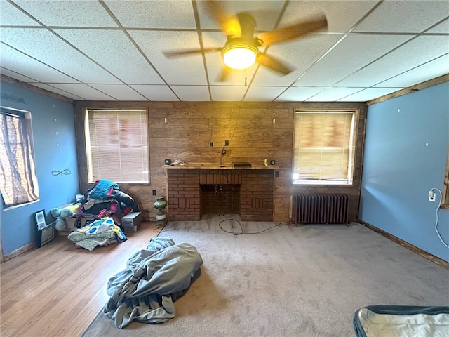 living room with ceiling fan, a healthy amount of sunlight, a paneled ceiling, and radiator