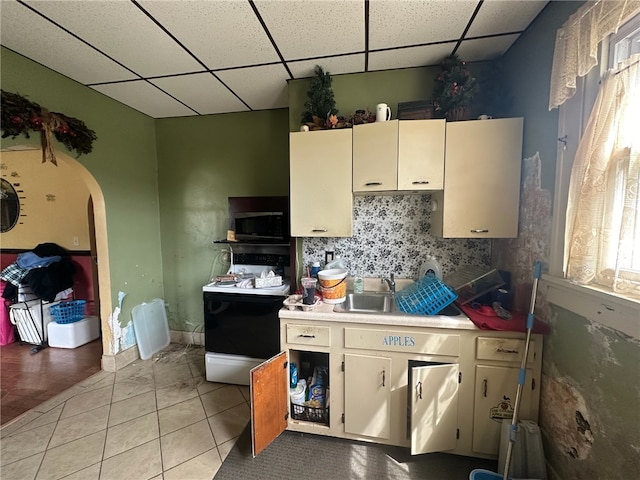 kitchen with a paneled ceiling, sink, and light tile flooring