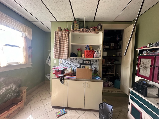 kitchen with light tile flooring and a drop ceiling