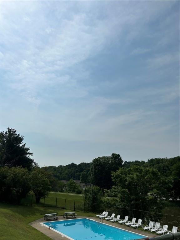 view of pool featuring a lawn