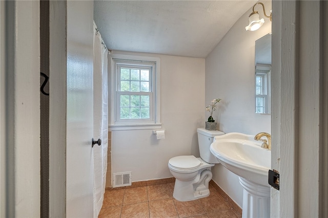 bathroom featuring toilet, a textured ceiling, and tile patterned flooring