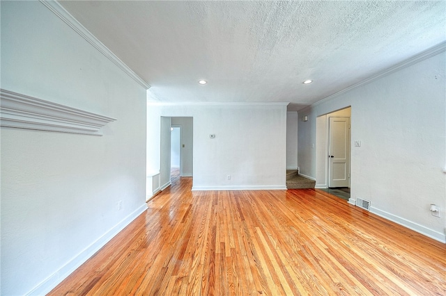 spare room with light hardwood / wood-style floors, crown molding, and a textured ceiling