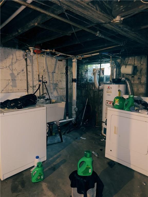 basement with washer and clothes dryer, water heater, sink, and fridge