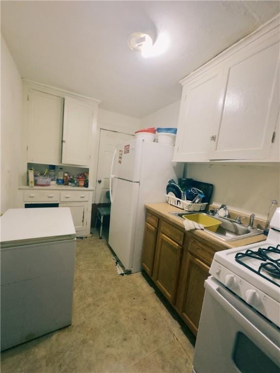 kitchen with white cabinets, white appliances, and sink