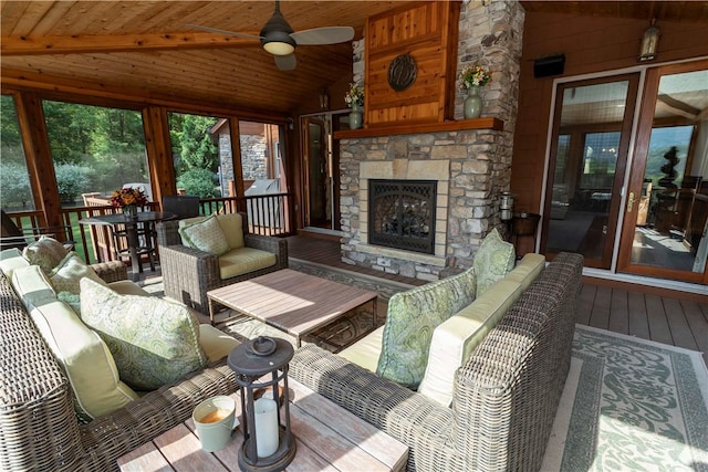 sunroom featuring an outdoor stone fireplace, ceiling fan, wooden ceiling, and lofted ceiling