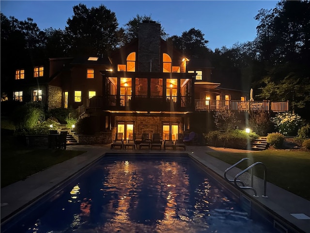 pool at dusk featuring a patio