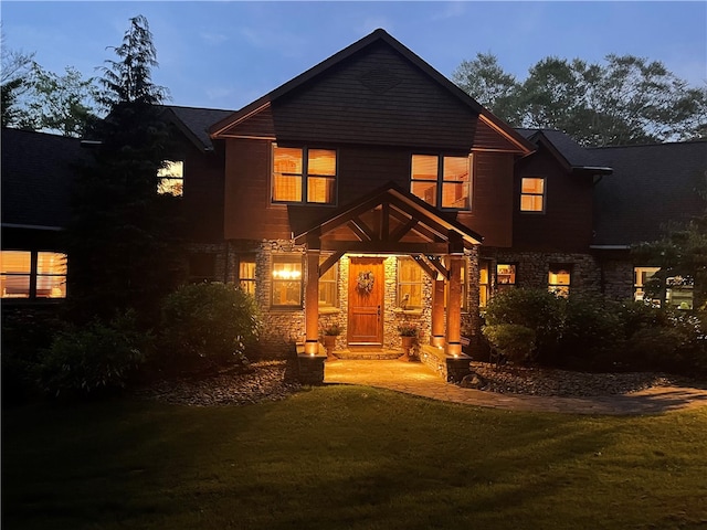 back house at dusk with a lawn