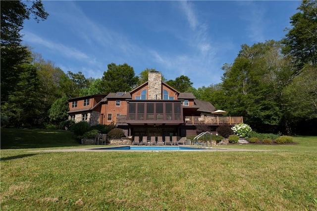 rear view of property featuring a sunroom and a yard