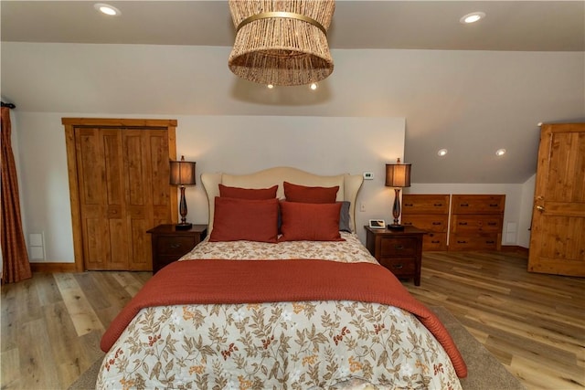 bedroom featuring light hardwood / wood-style floors and vaulted ceiling