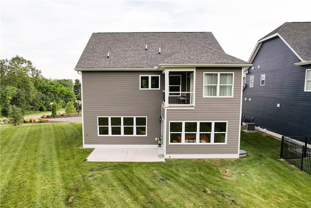 rear view of house with central AC unit, a patio area, and a lawn