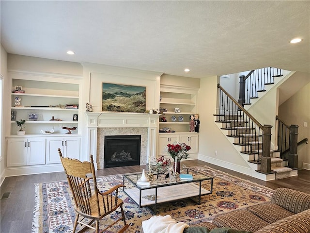 living room with built in features and dark wood-type flooring