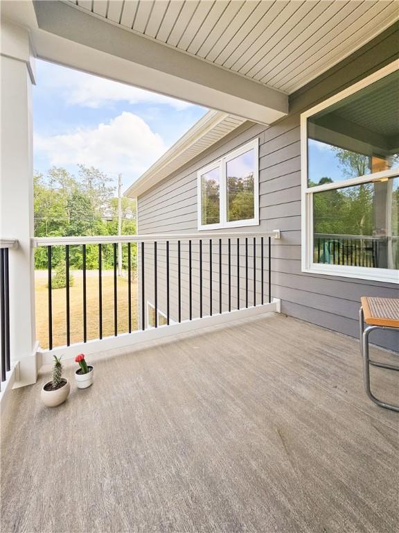 unfurnished sunroom featuring beam ceiling and plenty of natural light