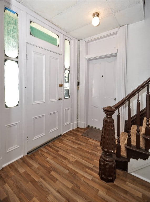 foyer with dark hardwood / wood-style floors and a drop ceiling