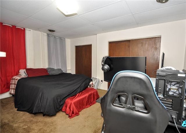 bedroom featuring carpet and a drop ceiling