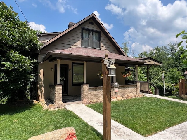 bungalow-style house featuring a porch, a front lawn, stucco siding, and a shingled roof