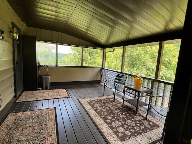 sunroom / solarium with a healthy amount of sunlight, lofted ceiling, and wood ceiling