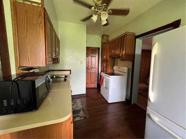 kitchen with white appliances, sink, dark wood-type flooring, and ceiling fan