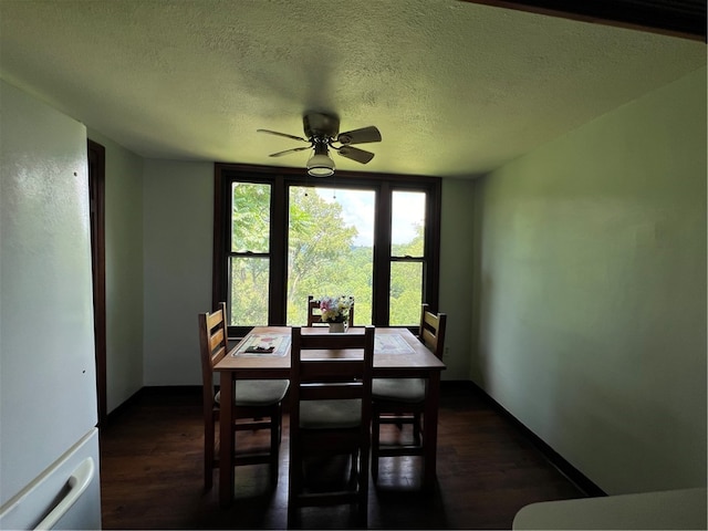 dining room featuring dark hardwood / wood-style flooring, ceiling fan, and a textured ceiling