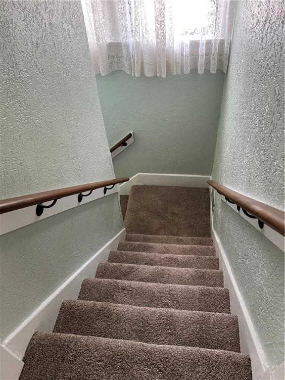 staircase with a textured wall