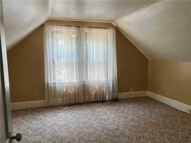 bonus room featuring plenty of natural light, carpet floors, and vaulted ceiling