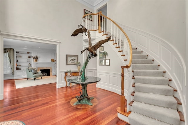 foyer with hardwood / wood-style flooring, ornamental molding, and a tile fireplace