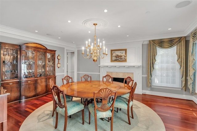 dining space featuring an inviting chandelier, crown molding, a fireplace, and dark wood-type flooring