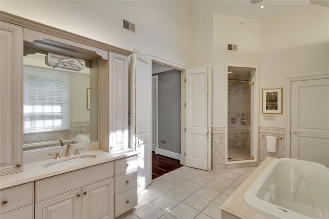 bathroom with separate shower and tub, tile patterned flooring, and vanity