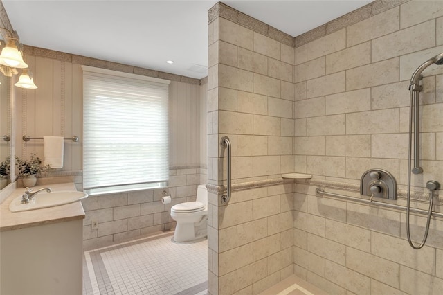 bathroom with tile patterned flooring, vanity, toilet, and tiled shower