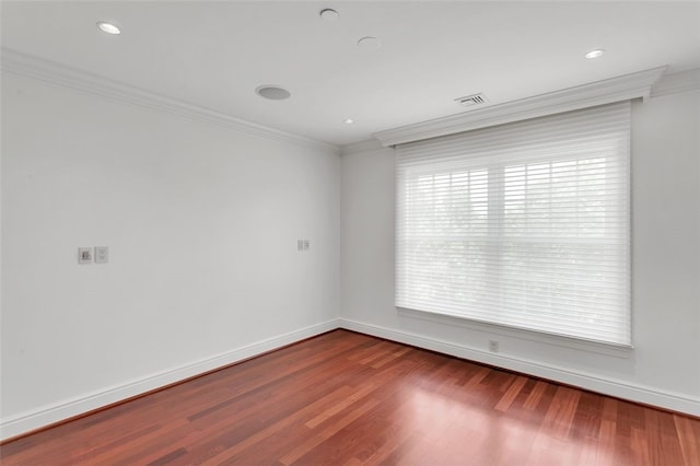 empty room featuring hardwood / wood-style flooring and crown molding