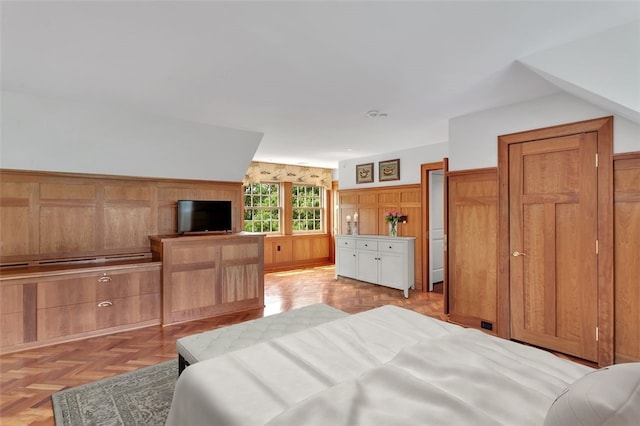 bedroom featuring wooden walls and light parquet floors