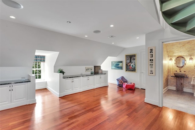 interior space with light hardwood / wood-style flooring and vaulted ceiling