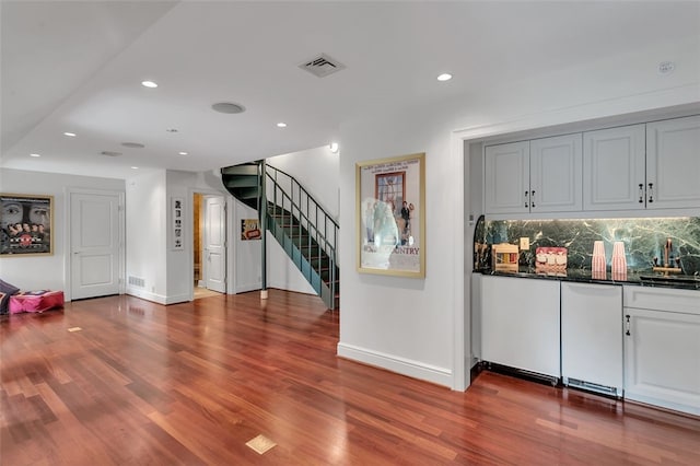 interior space featuring wood-type flooring and tasteful backsplash